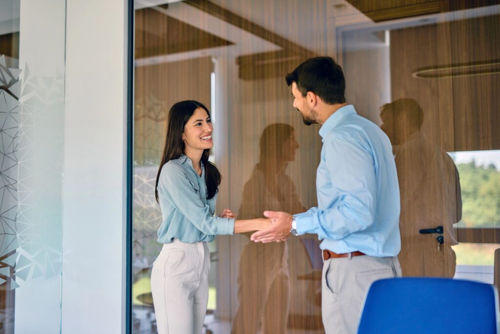 Businesspeople shaking hands in modern office meeting room